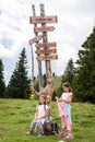 Children in frontÃÂ Wooden Signpost on Velika Planina in Slovenia Royalty Free Stock Photo